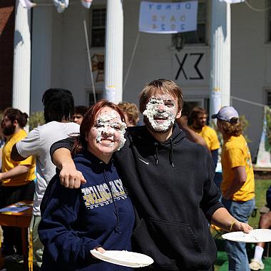 Two students pose together after having pied each other.